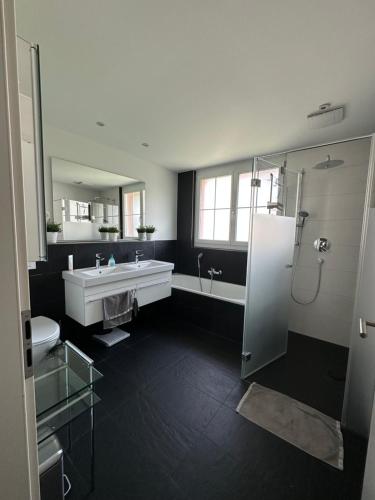 a bathroom with a tub and a sink and a shower at Gemütliches Haus in Knonau in Knonau