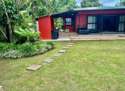 una casa rossa con un cortile con delle rocce davanti di Breath of Fresh air Suva Fiji a Suva
