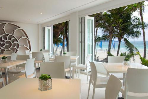 a restaurant with tables and chairs and a view of the beach at Privates Suites in Station 1 Boracay Island in Boracay