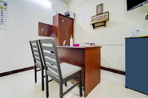 a desk with a chair in a room at Flagship Airport Inn in Irugūr