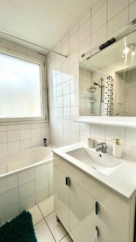 La salle de bains blanche est pourvue d'un lavabo, d'une baignoire et d'un miroir. dans l'établissement La Blue Room-Chambre Double Privée - 700m Stade de France, à Saint-Denis