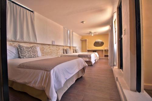 a hotel room with two beds and a hallway at Hotel Punto 79 in San Miguel de Allende