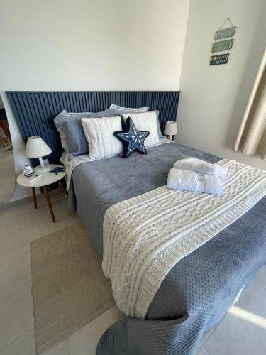 um quarto com uma cama grande e uma cabeceira azul em Loft Pelicano Prainhas- Pontal do Atalaia- Para Casal em Arraial do Cabo