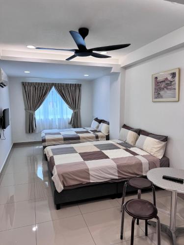 a bedroom with two beds and a ceiling fan at Famosa 2 Stay at Ong Kim Wee in Melaka