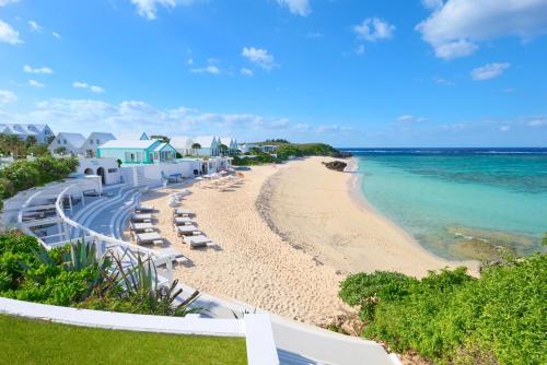 a beach with lounge chairs and the ocean at Pricia Resort Yoron in Yoron