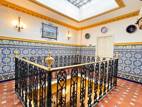 una escalera ornamentada en una casa con azulejos azules y blancos en Palace-House Hércules 92 en Sevilla