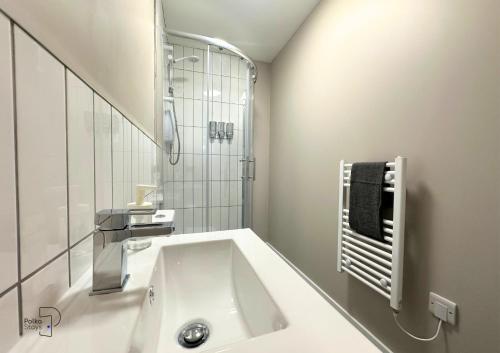 bagno bianco con lavandino e specchio di Hanley, Stoke - Modern Spacious Apartments by PolkaStays a Hanley