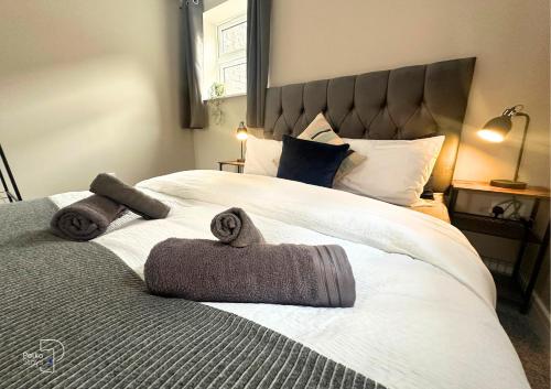 una camera da letto con un grande letto con asciugamani di Hanley, Stoke - Modern Spacious Apartments by PolkaStays a Hanley