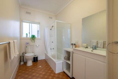 a bathroom with a shower and a toilet and a sink at Blissful Beach Escape in Balgownie in Balgownie