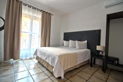 a bedroom with a bed and a large window at Hotel Punto 79 in San Miguel de Allende