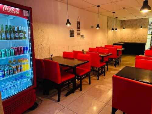 a restaurant with red chairs and a soda machine at on park hotel e estacionamento traslado in Guarulhos