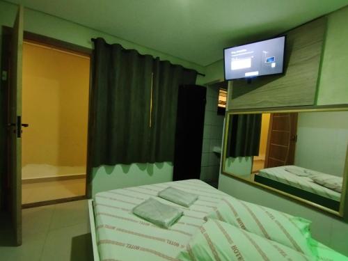 um quarto com uma cama com um espelho e uma televisão em Hotel motel Raiar do Sol santo Amaro em São Paulo