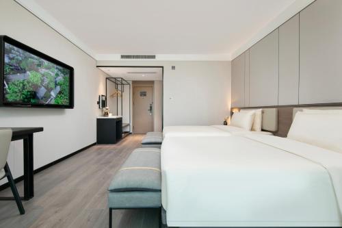 a hotel room with a large bed and a desk at Atour X Hotel Ningbo Railway Station North Square in Ningbo