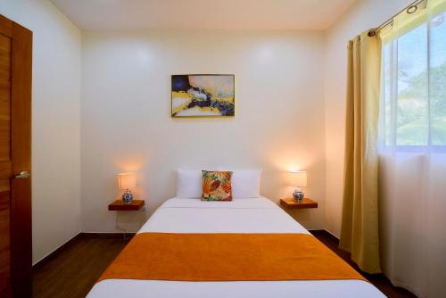 a small bedroom with a bed and two lamps at Olinca Boutique Hotel in Puerto Viejo