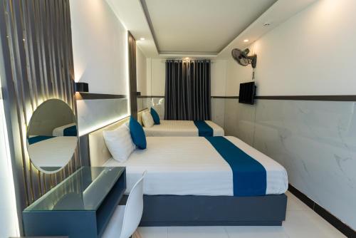 - une chambre d'hôtel avec un lit et un miroir dans l'établissement Prince Hotel, à Hô-Chi-Minh-Ville