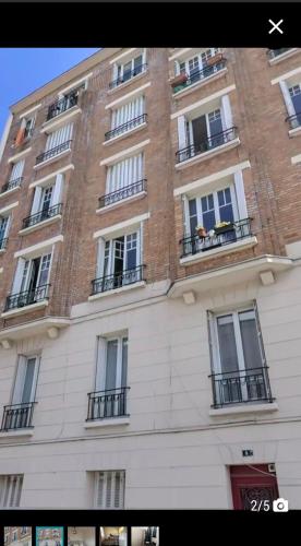 un grand bâtiment en briques avec des fenêtres et des balcons dans l'établissement Chez Babou J, à Saint-Denis