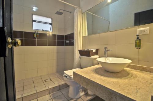 a bathroom with a sink and a toilet at Hotel Punto 79 in San Miguel de Allende