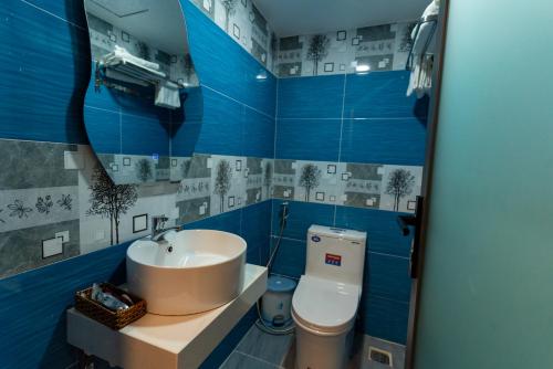 La salle de bains bleue est pourvue d'un lavabo et de toilettes. dans l'établissement Prince Hotel, à Hô-Chi-Minh-Ville