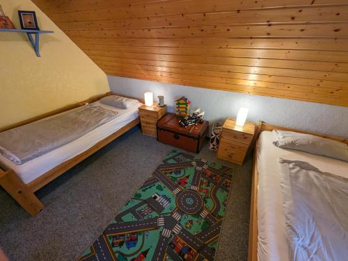 a bedroom with two beds and a rug at Haus Piratenperle - Hooksiel in Wangerland