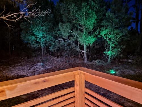 a wooden fence in front of some trees at night at LOBOS DEL BOSQUE CON JACUZZi in Punta Del Diablo