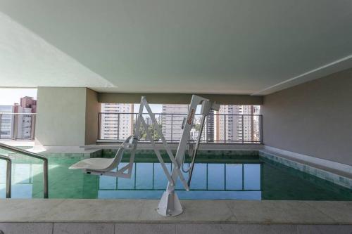 uma piscina com uma cadeira num edifício em Studio Luxo Allianz Parque- Excelente Custo em São Paulo