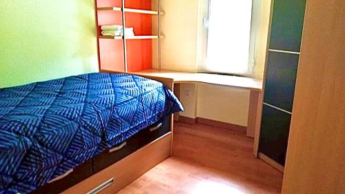 a small bedroom with a bed and a window at Acogedor piso en Puertollano in Puertollano