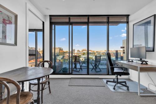an office with a desk with a computer and chairs at Tranquil 1-Bed Haven with Swimming Pool by CBD in Melbourne