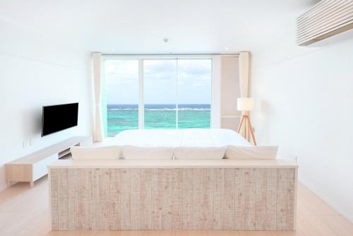 a bedroom with a bed and a large window at Pricia Resort Yoron in Yoron