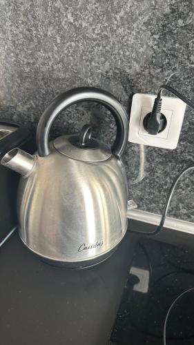 a silver tea kettle on a counter with a socket at Appartement avec terrasse in Vierzon