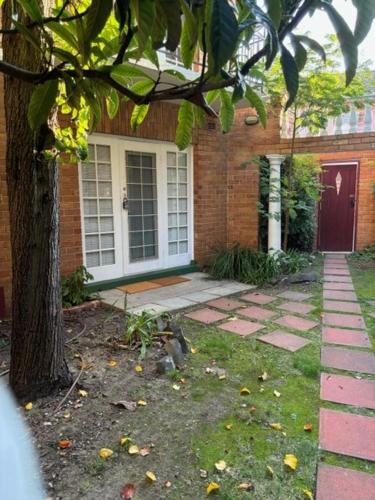 a brick house with a door and a tree at Regents Gate 53 in Melbourne