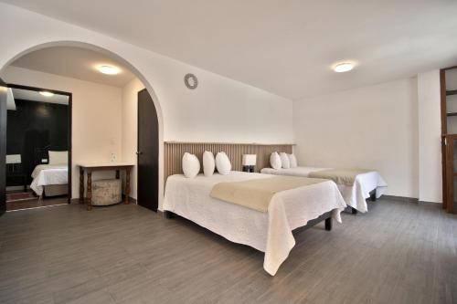 a hotel room with two beds and a mirror at Hotel Punto 79 in San Miguel de Allende