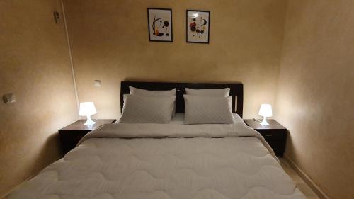 馬拉喀什的住宿－Cozy apartment in the heart of marrakech，一间卧室配有一张大床,上面有两盏灯