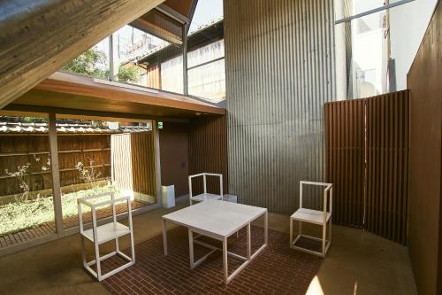 een kamer met een tafel en twee witte stoelen bij A&A Okayama in Okayama