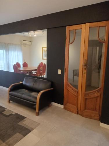 Una sala de estar con un sofá de cuero y una mesa. en Departamento Verbenas Céntrico con cochera, en Santa Rosa