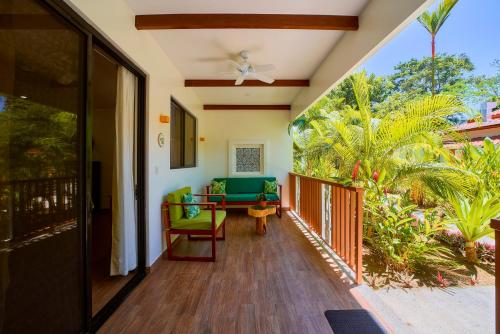 an open porch with a green couch on a house at Olinca Boutique Hotel in Puerto Viejo