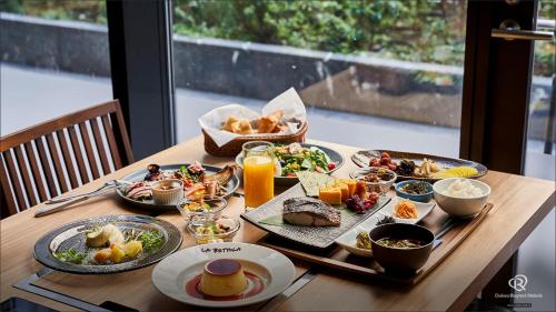 a wooden table with plates of food on it at Daiwa Roynet Hotel Shimbashi in Tokyo