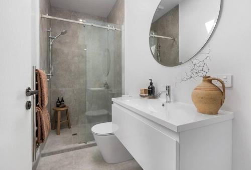 bagno con lavandino e doccia con specchio di Tranquility in Travis a Christchurch