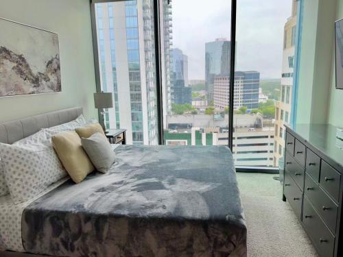 1 dormitorio con cama y ventana grande en Ruby Retreat - Highrise! Balcony,Pool,City View, en Atlanta