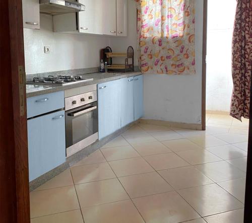 a kitchen with white appliances and a tile floor at Charming house in Agadir