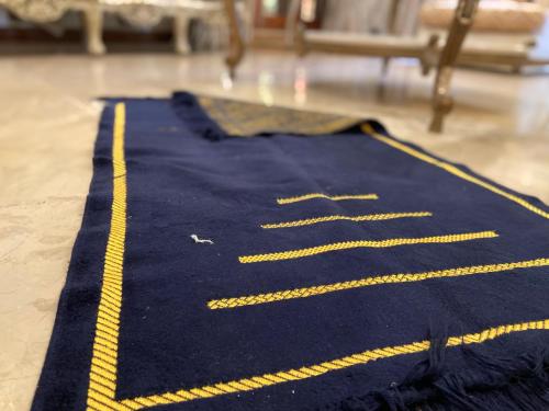 a blue rug with yellow stripes on a floor at E Lodge in Islamabad