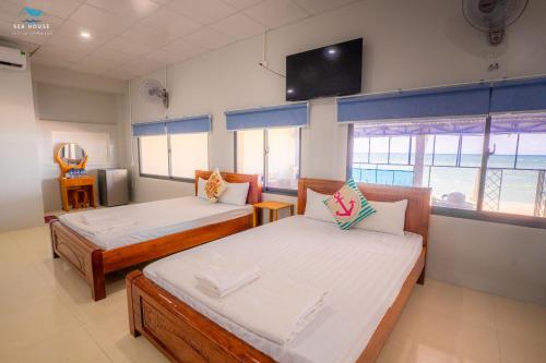Zimmer mit 2 Betten und einem Flachbild-TV in der Unterkunft Sea House in Ấp Bình Hưng