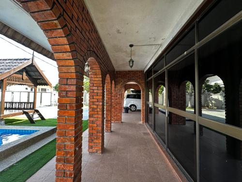 an external view of a building with a brick wall at Mawar 23 Chendering with Private Pool in Kuala Terengganu