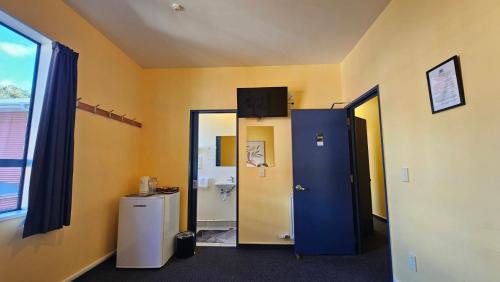 a bathroom with a blue door and a toilet at Franz Josef Montrose Lodge in Franz Josef