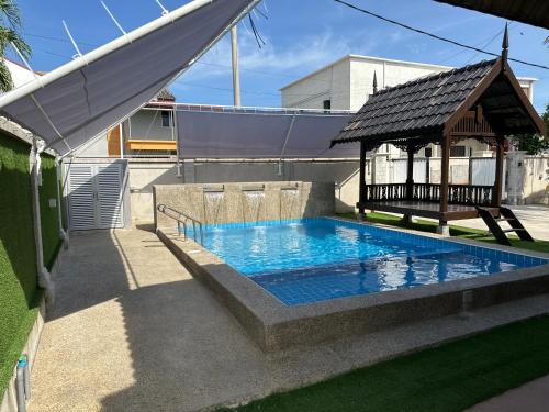 a swimming pool with a gazebo in a backyard at Mawar 23 Chendering with Private Pool in Kuala Terengganu
