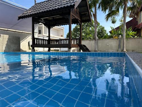 a swimming pool with a gazebo in a house at Mawar 23 Chendering with Private Pool in Kuala Terengganu