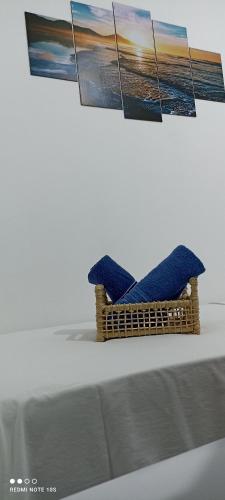a wicker basket with three pictures on a wall at Pousada Ray Sol - Centro Arraial d Ajuda in Arraial d'Ajuda