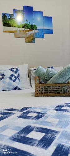 a bedroom with a bed with some pictures on the wall at Pousada Ray Sol - Centro Arraial d Ajuda in Arraial d'Ajuda