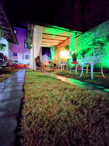 a house with green lights on a yard at night at Pousada Ray Sol - Centro Arraial d Ajuda in Arraial d'Ajuda