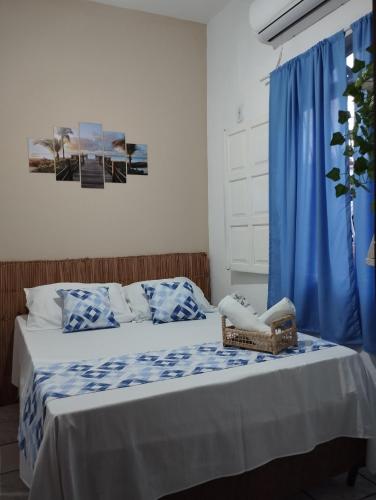 a bedroom with a bed with a basket on it at Pousada Ray Sol - Centro Arraial d Ajuda in Arraial d'Ajuda