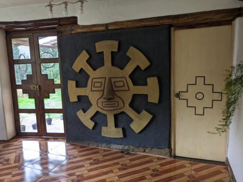a room with a large wall with a wooden floor and a large at Elegua Casa Medicina in Pisac